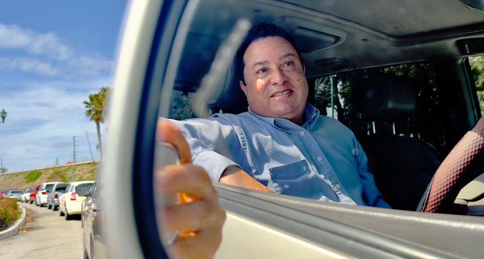 Enrique Lucero of Oxnard waits 90 minutes in a line of 900 cars to pick up items from regional food bank Food Share at Oxnard's College Park on Wednesday, March 15, 2023.