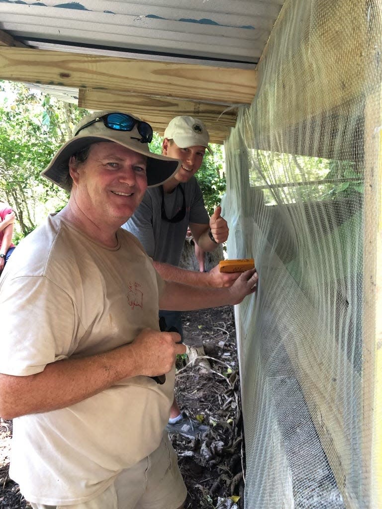 Campbell Vaughn and Lee Perry work on putting on a roof for a cistern during a summer mission trip to Jamaica.