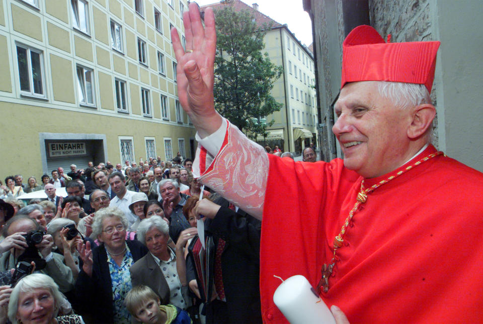 FILE - The Vatican's Prefect for the Doctrine of the Faith, Cardinal Joseph Ratzinger, later to become Pope Benedict XVI, waves to faithful following a mass on the occasion of the 50th anniversary of his priest ordination in the cathedral of Munich, southern Germany, July 8, 2001. The Vatican on Wednesday, Jan. 26, 2022 strongly defended Pope Benedict XVI’s record in fighting clergy sexual abuse and cautioned against looking for “easy scapegoats and summary judgments,” after an independent report faulted his handling of four cases of abuse when he was archbishop of Munich, Germany. (AP Photo/Diether Endlicher, File)