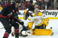 Nashville Predators goaltender Juuse Saros (74) keeps an eye on the puck as Carolina Hurricanes left wing Steven Lorentz (78) and left wing Brock McGinn (23) try to get a shot during the second period in Game 1 of an NHL hockey Stanley Cup first-round playoff series in Raleigh, N.C., Monday, May 17, 2021. (AP Photo/Gerry Broome)