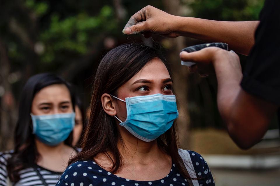 PARANAQUE, PHILIPPINES - FEBRUARY 26: Catholic devotees wearing protective masks fall in line to have their head sprinkled with ash during Ash Wednesday services at a church on February 26, 2020 in Paranaque city, Metro Manila, Philippines. The Philippines Catholic Church has recommended sprinkling ash on the heads of devotees, rather than the usual practice of rubbing it on foreheads, to avoid physical contact as a precaution against COVID-19. The first COVID-19 death outside of China was reported in the Philippines last February 2, while the country has reported only 3 confirmed cases of the coronavirus so far. With over 78,000 confirmed cases around the world, the virus has so far claimed over 2,700 lives. (Photo by Ezra Acayan/Getty Images)