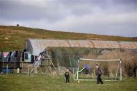 Five-year-old Roan and 14-year old Euan play football as their father Ronnie Eunson (unseen) prepares breakfast in their croft near the village of Scalloway on the Shetland Islands April 1, 2014. REUTERS/Cathal McNaughton