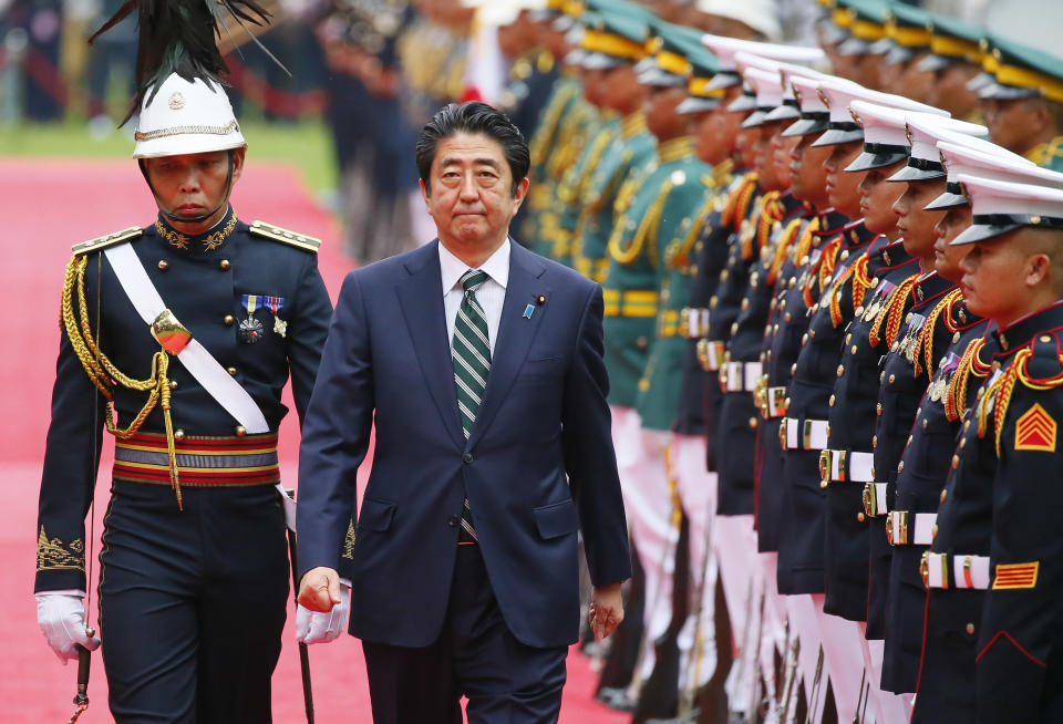 Japanese Prime Minister Shinzo Abe reviews the troops during a welcoming ceremony at the Malacanang Palace grounds, Thursday, Jan. 12, 2017, in Manila, Philippines. Abe arrived Thursday for a two-day official visit that includes a visit to President Rodrigo Duterte's hometown of Davao city in southern Philippines. (AP Photo/Bullit Marquez)