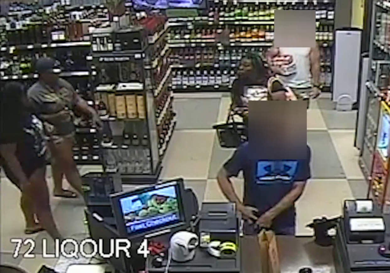 Ta'Kiya Young, standing in line at right, is joined by two other women in the liquor store of a Kroger in Blendon Township on August 24 before all three leave the store together.