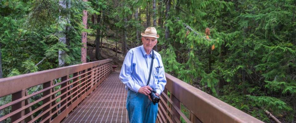 Healthy Active Senior Photographer Hiking Outdoors. Copy space.