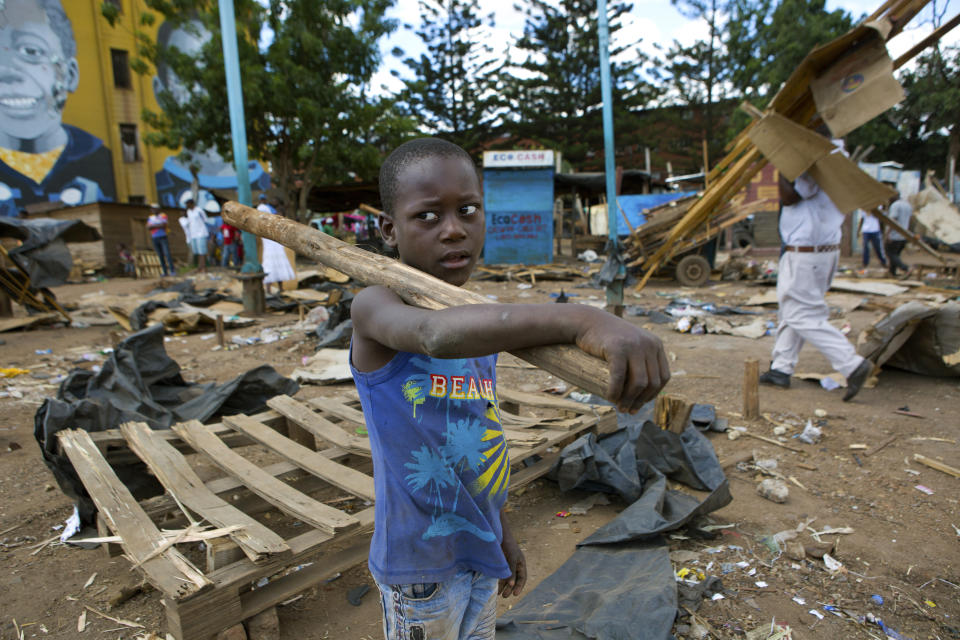 A boy picks up wood from destroyed stalls in the area of a popular market in a campaign to clean up the city, in Harare, Zimbabwe, Saturday, April 18, 2020. Zimbabwe will commemorate its 40th Independence Day under the government instructed lockdown in an effort to curb the spread of coronavirus. (AP Photo/Tsvangirayi Mukwazhi)