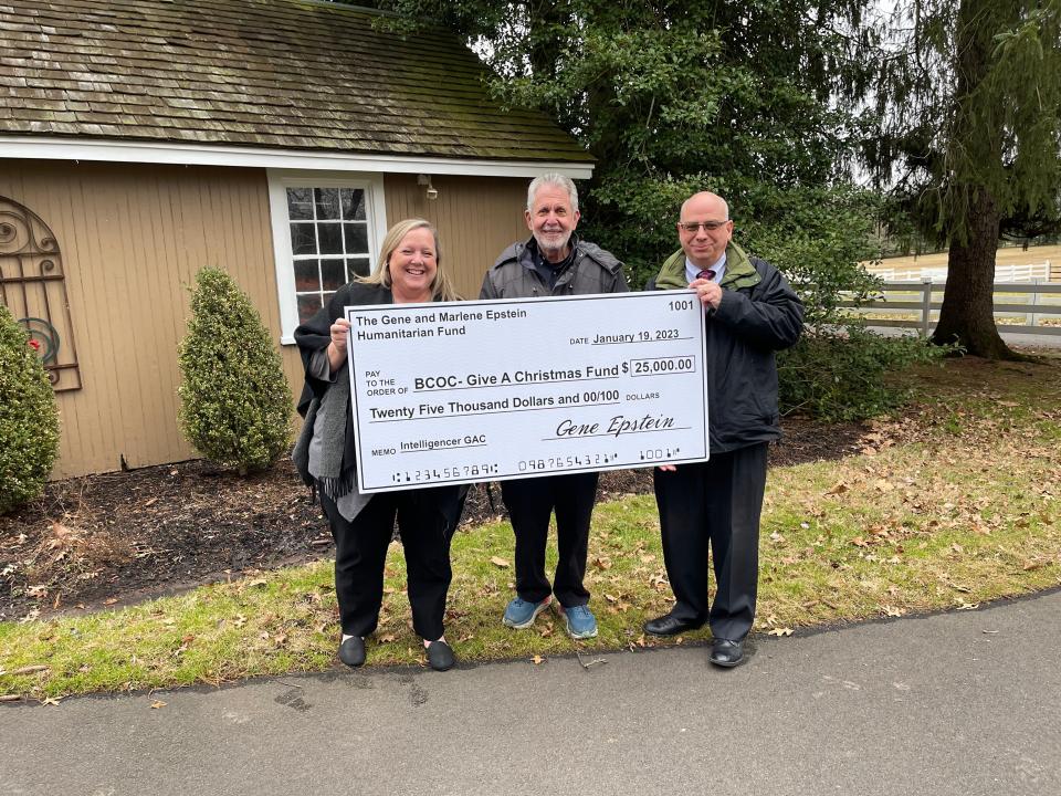 Local philanthropist Gene Epstein, center, presents a check for the Intelligencer and Bucks County Opportunity Council's Give A Christmas fund.