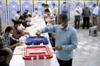 A voter casts his ballot for the presidential election at a polling station in Tehran, Iran, Friday, June 18, 2021. Iranians voted Friday in a presidential election that a hard-line protege of Supreme Leader Ayatollah Ali Khamenei seemed likely to win, leading to low turnout fueled by apathy and calls for a boycott. (AP Photo/Ebrahim Noroozi)