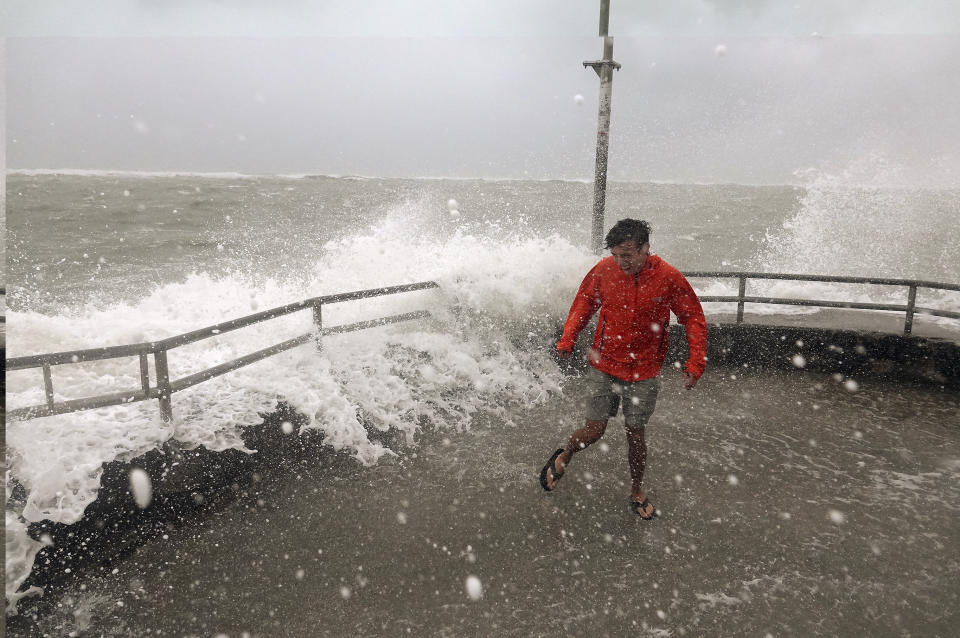 Brandon Ennis runs away from waves caused by Hurricane Dorian crashing over the jetty of the Jupiter inlet, Tuesday, Sept. 3, 2019, in Jupiter, Fla. (Photo: Joe Cavaretta/South Florida Sun-Sentinel via AP)