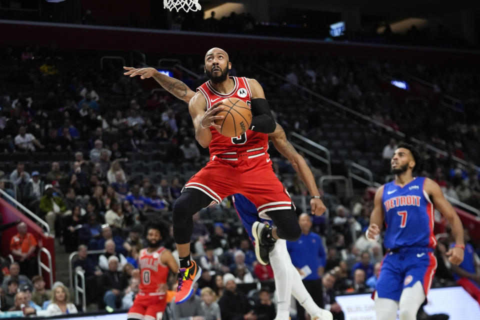 Chicago Bulls guard Jevon Carter (5) drives on Detroit Pistons guard Marcus Sasser in the first half of an NBA basketball game in Detroit, Thursday, April 11, 2024. (AP Photo/Paul Sancya)