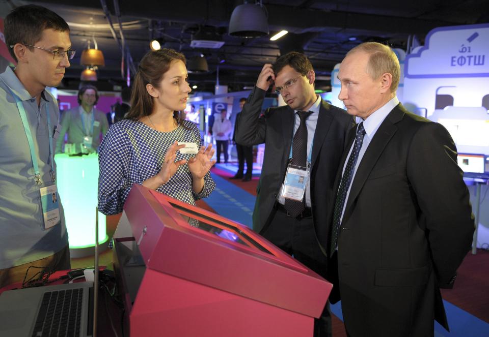 Russia's President Vladimir Putin (R) listens to explanations as he attends an exhibition on internet projects, part of a forum dedicated to internet entrepreneurial business, in Moscow, June 10, 2014. Putin said on Tuesday a fight against illegal content on the Internet should not become a fight against freedom, seeking to calm fears over a possible clampdown on media and social networking sites. REUTERS/Alexei Druzhinin/RIA Novosti/Kremlin (RUSSIA - Tags: POLITICS SCIENCE TECHNOLOGY BUSINESS) ATTENTION EDITORS - DISTRIBUTED, EXACTLY AS RECEIVED BY REUTERS, AS A SERVICE TO CLIENTS. THIS IMAGE HAS BEEN SUPPLIED BY A THIRD PARTY. IT IS DISTRIBUTED, EXACTLY AS RECEIVED BY REUTERS, AS A SERVICE TO CLIENTS