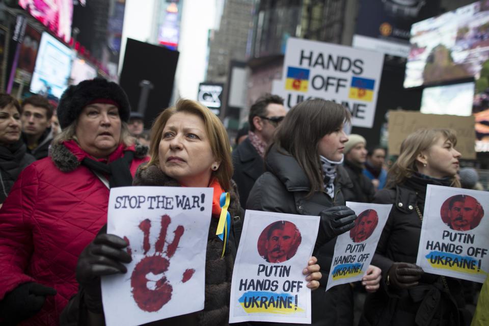 Demonstrators against Russian military actions in Ukraine rally in Times Square, Sunday, March 2, 2014, in New York. Western powers are prepared "to go to the hilt" to isolate Russia for its military incursion into Ukraine, "an incredible act of aggression" that may lead to visa bans, asset freezes, trade and investment penalties, and a boycott of a Russian-hosted economic summit of global powers in June, Secretary of State John Kerry said Sunday. (AP Photo/John Minchillo)