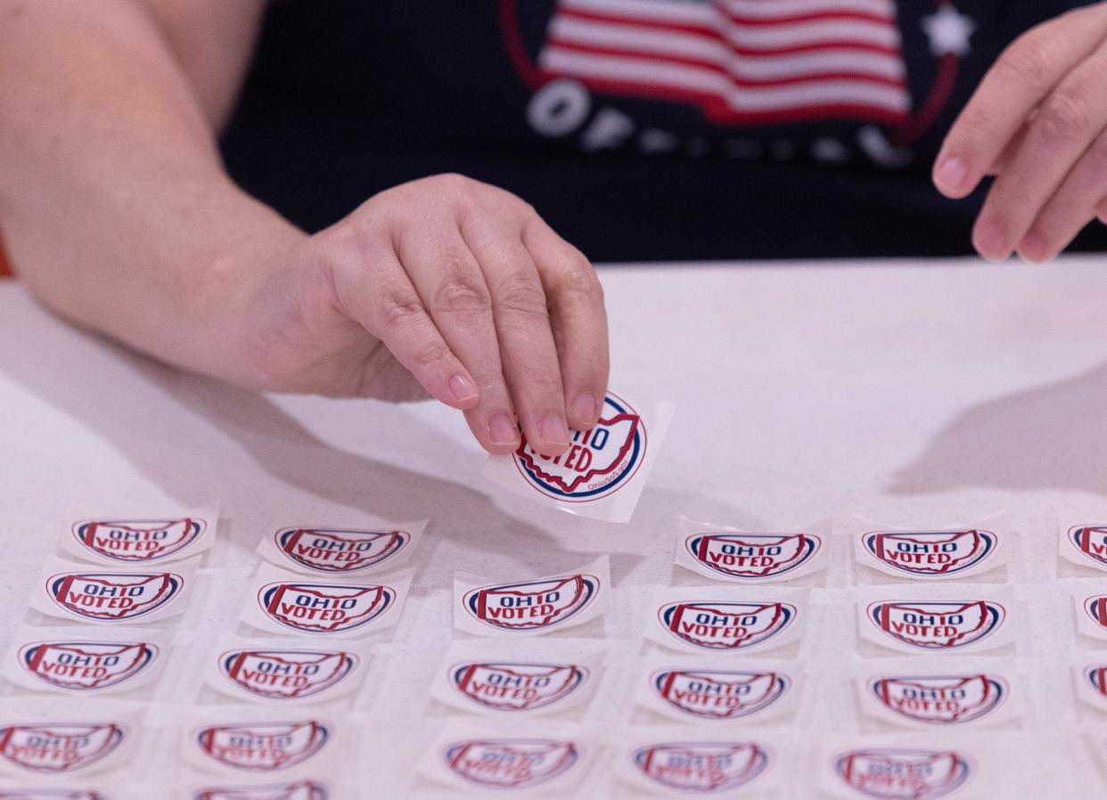 Poll worker Carol Shaw gets an "Ohio Voted" sticker for a voter during the 6th Congressional District special election at Perry Christian Church in June.