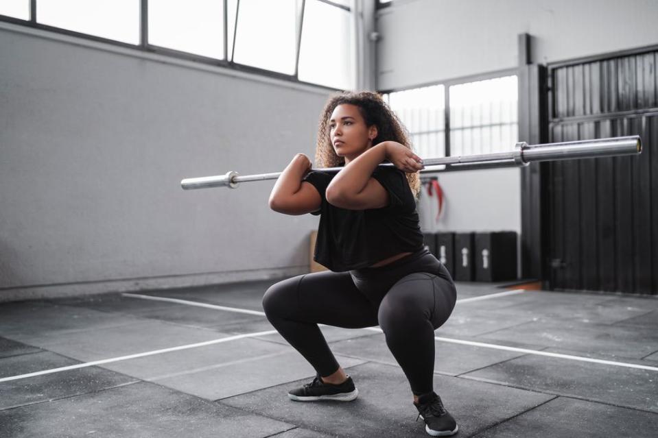 Mujer haciendo una sentadilla frontal