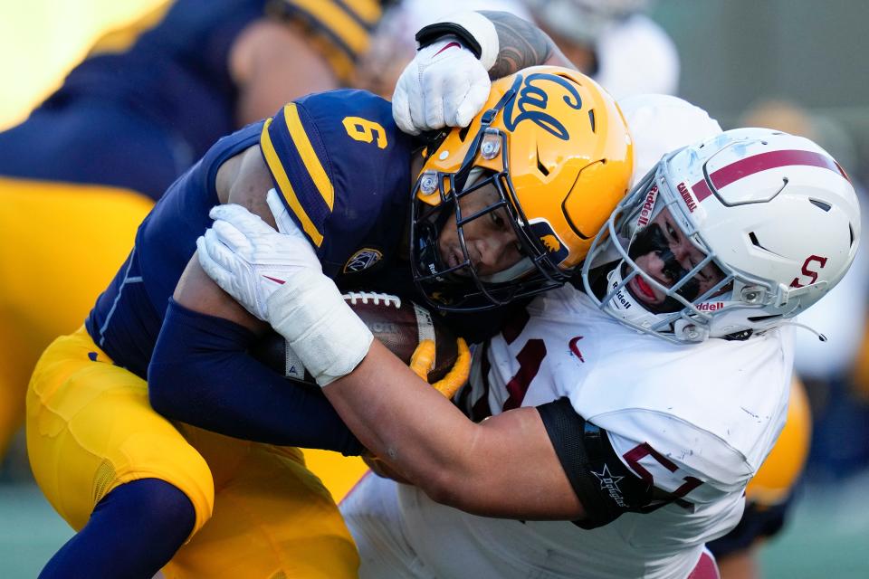 Stanford defensive lineman Jaxon Moi puts the squeeze on California running back Jaydn Ott (6) during a 2022 game. Ott leads the Pac-12 this season with 1,260 rushing yards and 1,501 all-purpose yards, figures that rank seventh and eighth, respectively, in the FBS.