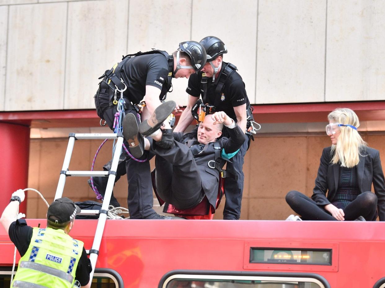Police remove a climate change protester who had glued himself to the roof of a train: AFP/Getty Images