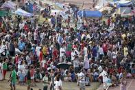 Residents who were displaced from their homes due to fighting between government soldiers and Muslim rebels from the Moro National Liberation Front (MNLF) wait for the distribution of food at a sports complex, which has been turned into an evacuation centre, in Zamboanga city in southern Philippines September 14, 2013. (REUTERS/Erik De Castro)