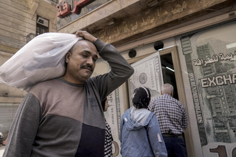 An Egyptian man walks past an exchange office in Cairo, Egypt, Wednesday, March 6, 2024. The Egyptian pound slipped sharply against the dollar on Wednesday after the Central Bank of Egypt raised its main interest rate and said it would allow the currency's exchange rate to be set by market forces. (AP Photo/Amr Nabil)