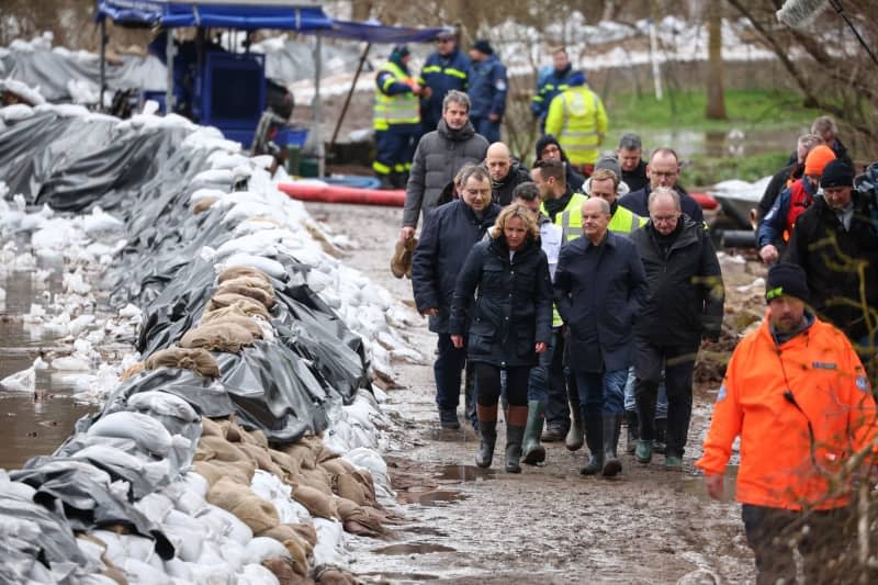 German Chancellor Olaf Scholz (C), Reiner Haseloff (R), Minister President of Saxony-Anhalt, and Steffi Lemke (L), Federal Minister for the Environment, Nature Conservation, Nuclear Safety and Consumer Protection, walk along a dyke built from sandbags. On the same day, Chancellor Scholz and Saxony-Anhalt's Minister President Haseloff will visit the flood area around the Helme and talk to volunteers. Jan Woitas/dpa