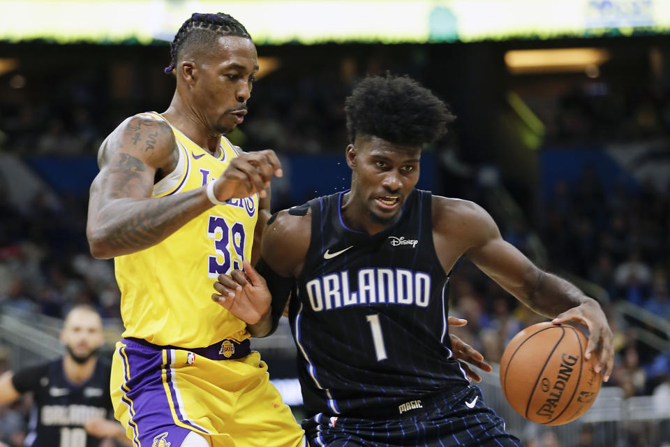 Orlando Magic's Jonathan Isaac (1) looks for a path to the basket against Los Angeles Lakers' Dwight Howard, left, during the second half of an NBA basketball game, Wednesday, Dec. 11, 2019, in Orlando, Fla. (AP Photo/John Raoux)