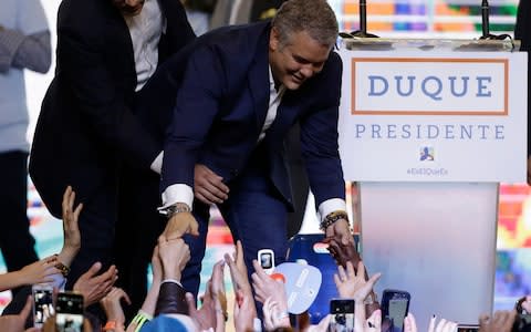 President Elect Ivan Duque shakes hands with supporters after his victory in the presidential runoff election in Bogota - Credit: AP