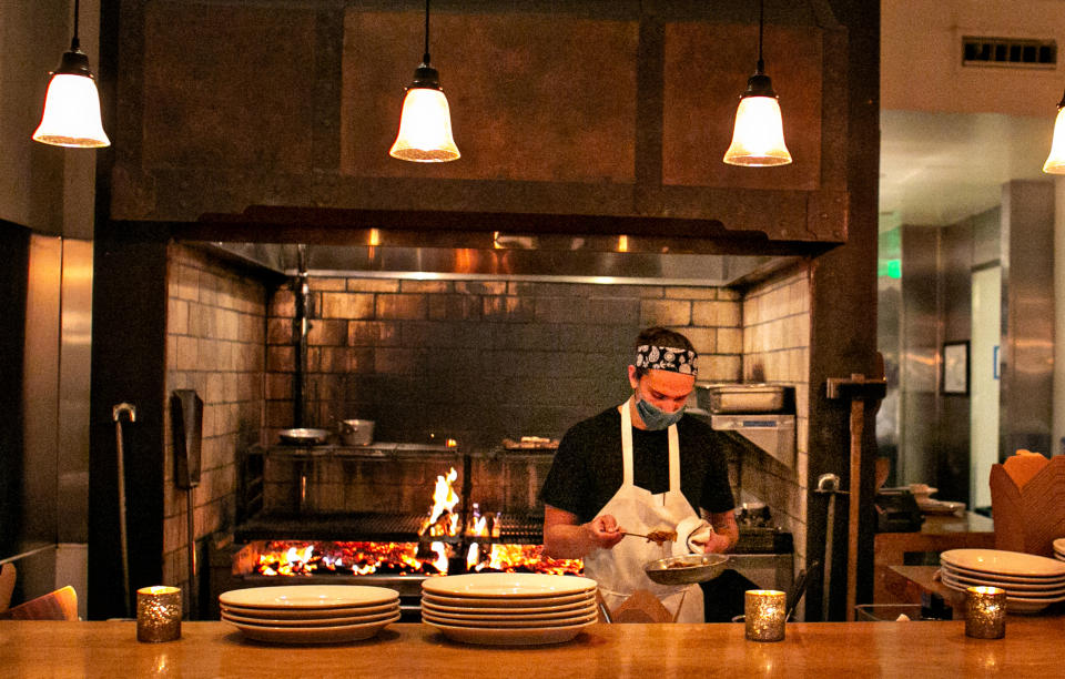 SANTA MONICA, CA - MAY 05: GJ Stinson, chef de tournant at Cassia, works the wood fire grills station as the much loved restaurant re-opens its indoor dining and continues outdoor dining on Wednesday, May 5, 2021 in Santa Monica, CA. (Jason Armond / Los Angeles Times via Getty Images)