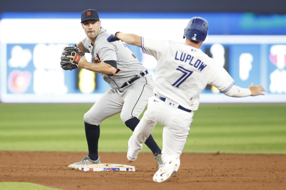 Detroit Tigers shortstop Ryan Kreidler, left, forces out Toronto Blue Jays' Jordan Luplow (7) and throws to first base to complete a double play on a ball hit by Blue Jays' Brandon Belt in the eighth inning of a baseball game in Toronto, Thursday, April 13, 2023. (Cole Burston/The Canadian Press via AP