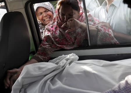 The sister of Aftab Bahadur touches her brother's face after his body was placed in a van to be taken for burial following his execution at Kot Lakhpat jail in Lahore, Pakistan, in this June 10, 2015 file photo. REUTERS/Mohsin Raza/Files