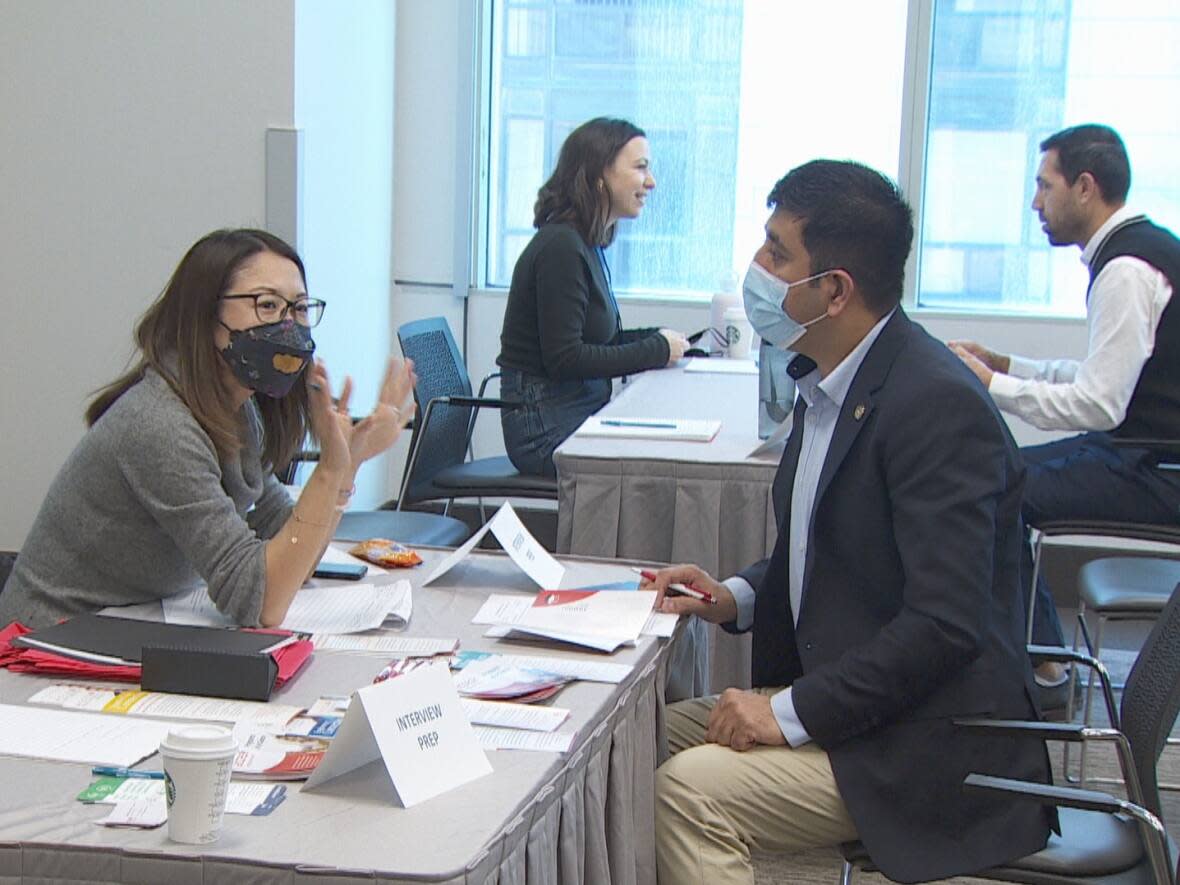 At the Toronto Refugee Hiring Event in Metro Hall, some refugees received a job offer on the spot, others got a second interview, and still others were flagged for future job opportunities. Job seekers will also had access to a 'coaching corner,' pictured here, where they were able to receive interview tips from employment consultants. (CBC - image credit)