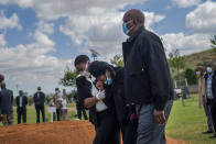 FILE - In this Thursday, April 16, 2020 file photo, relatives grieve coffee shop manager Benedict Somi Vilakasi, who died of a COVID-19 infection in a Johannesburg hospital, at his burial ceremony at the Nasrec Memorial Park outside Johannesburg. More than two dozen international aid organizations have told the U.S. government they are "increasingly alarmed" that "little to no U.S. humanitarian assistance has reached those on the front lines" of the coronavirus pandemic as the number of new cases picks up speed in some of the world's most fragile regions. (AP Photo/Jerome Delay, File)
