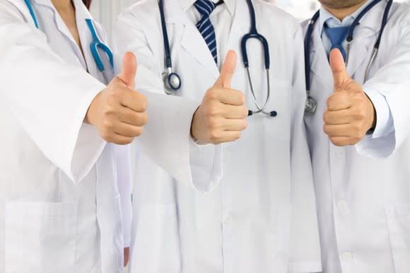 Group of three doctors giving the thumbs up