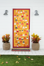 <p>Can't figure out what to put on your door? Get inspired by your favorite <a href="https://www.countryliving.com/food-drinks/g615/halloween-sweets-1008/" rel="nofollow noopener" target="_blank" data-ylk="slk:Halloween sweets;elm:context_link;itc:0;sec:content-canvas" class="link ">Halloween sweets</a>—like candy corn!</p><p><strong>Make the Candy Corn Door: </strong>Create a candy corn-inspired "quilt." Paint wide stripes, using acrylic paint (we used orange, mustard, cranberry, and gray), on thick artist's paper. Once dry, cut into equal-size triangles. Cut a 2-inch paper trim in a corresponding color. Attach to door using double- sided tape. Add whitewashed woven planters and "Lobster Rope" doormat. </p>