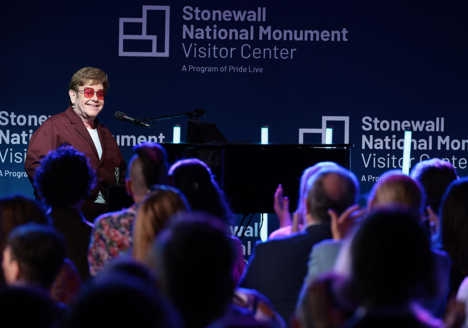 Elton John sits at a piano during the grand opening ceremony for the Stonewall National Monument Visitor Center