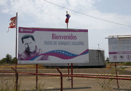 A billboard with an image of the late Venezuelan President Hugo Chavez is seen outside a refinery in Ciudad Ojeda, in the state of Zulia, Venezuela, March 20, 2015.REUTERS/Isaac Urrutia