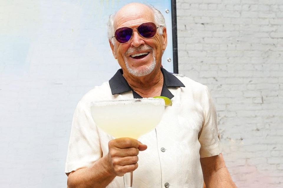 <p>Sean Zanni/Patrick McMullan via Getty</p> Jimmy Buffett with a margarita from his Margaritaville Resort