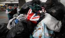 Antonio de Carvalho from Green World Recycling sorts through bags of clothing at the company's facility in Stourbridge, Britain