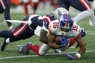 New York Giants wide receiver Collin Johnson (15) is brought down by New England Patriots cornerback Terrance Mitchell during the first half of a preseason NFL football game Thursday, Aug. 11, 2022, in Foxborough, Mass. (AP Photo/Charles Krupa)