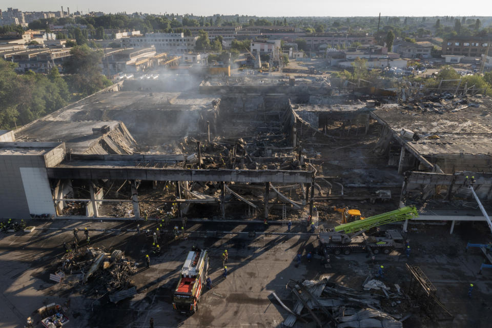 Ukrainian State Emergency Service firefighters work to take away debris at a shopping center burned after a rocket attack in Kremenchuk, Ukraine, Tuesday, June 28, 2022. (AP Photo/Efrem Lukatsky)