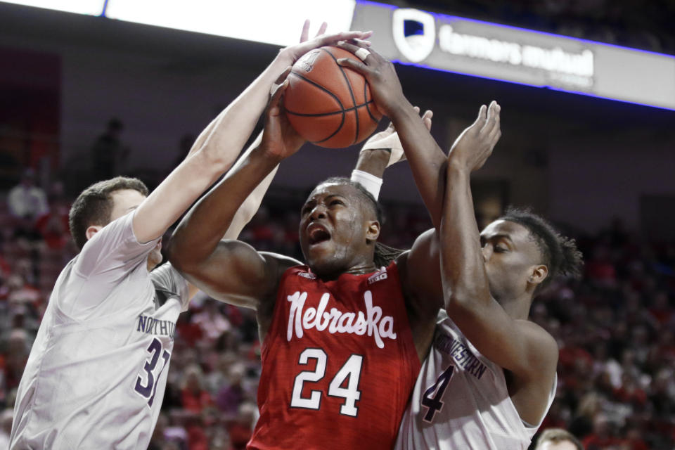 Nebraska's Yvan Ouedraogo (24) is fouled as he goes to the basket against Northwestern's Robbie Beran (31) and Jared Jonesc(4), during the first half of an NCAA college basketball game in Lincoln, Neb., Sunday, March 1, 2020. (AP Photo/Nati Harnik)