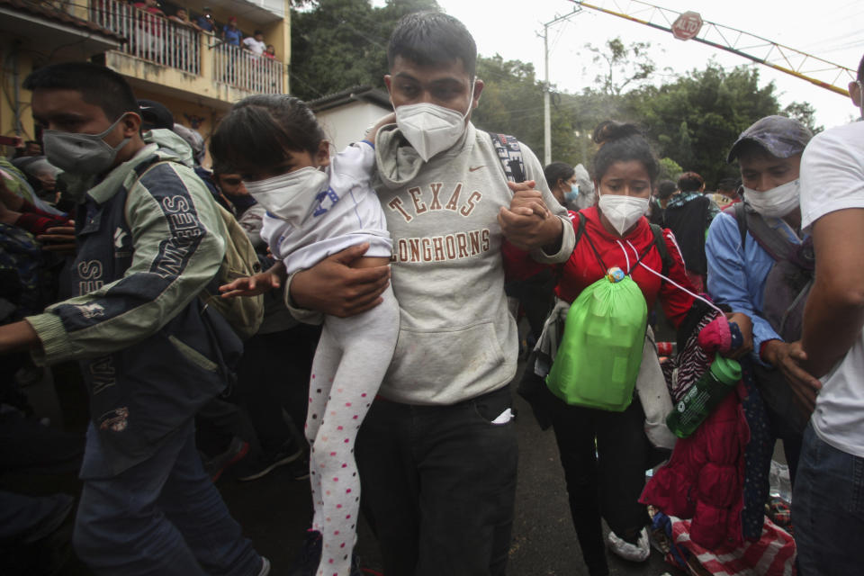 Honduran migrants hoping to reach the U.S. cross the border patrolled by Guatemalan soldiers, in El Florido, Guatemala, Saturday, Jan. 16, 2021. The migrants pushed their way into Guatemala Friday night without registering, a portion of a larger migrant caravan that had left the Honduran city of San Pedro Sula before dawn, Guatemalan authorities said. (AP Photo/Sandra Sebastian)