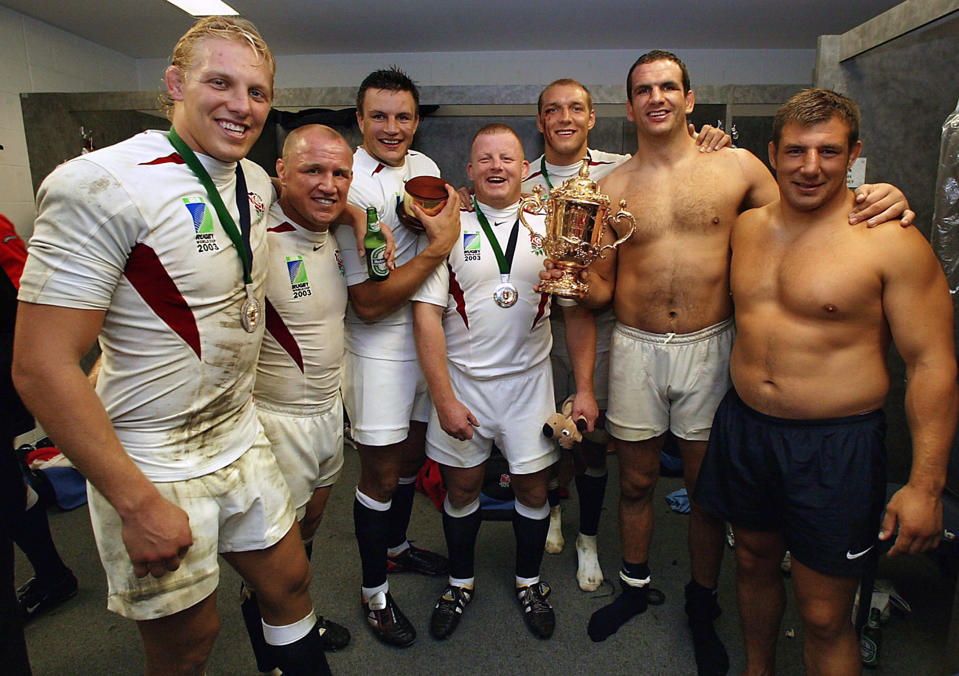 England players (as well as all being Leicester Tigers), from left, Lewis Moody, Neil Back, Martin Corry, Dorian West, Ben Kay, captain Martin Johnson, and Julian White celebrate in the dressing rooms with the William Webb Ellis trophy after their win in the Rugby World Cup final against Australia, in Sydney. England defeated Australia 20-17 in extra time.   (Photo by PA Images via Getty Images)