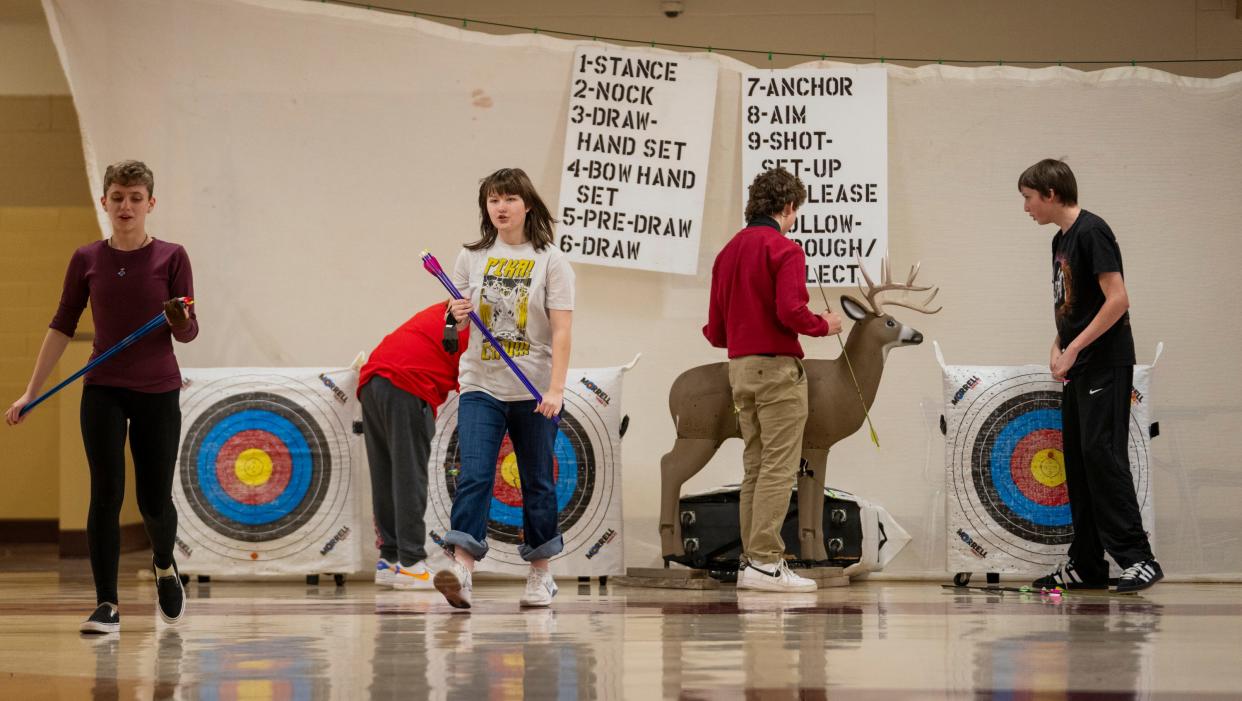 Archers head back to the line after pulling arrows from their targets on Tuesday, Feb. 6, in the basement of Scecina Memorial High School. About ten students take part in the after school club at the high school, in the Little Flower neighborhood of Indianapolis.