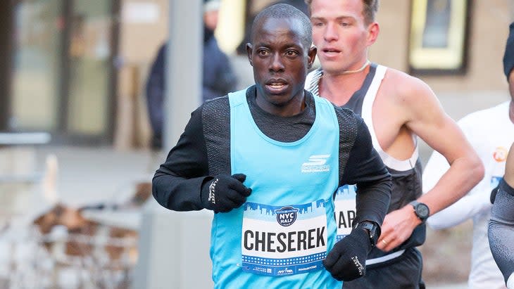 A man in a blue singlet runs a half marathon