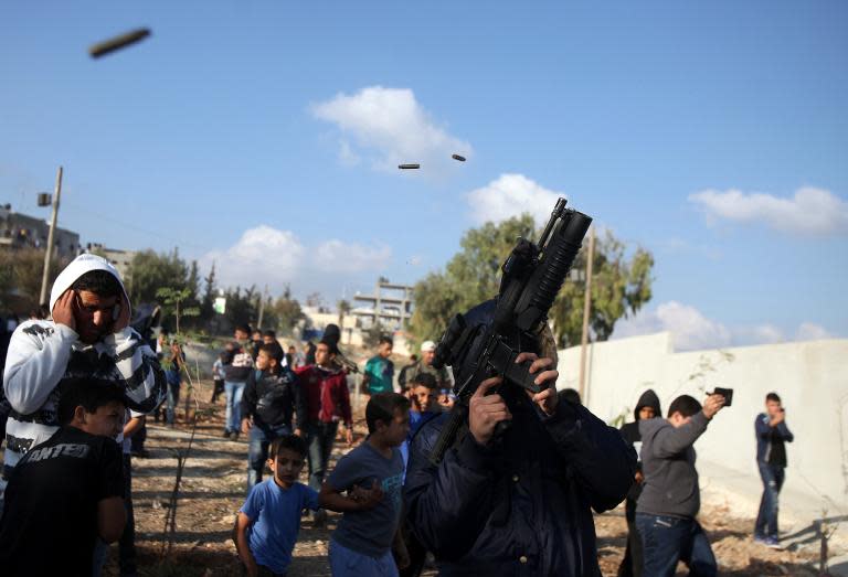 A Fatah gunman fires rounds into the air in the West Bank's Qalandia refugee camp on November 15, 2013, during a march to mark the 1988 symbolic independence declaration of Palestine