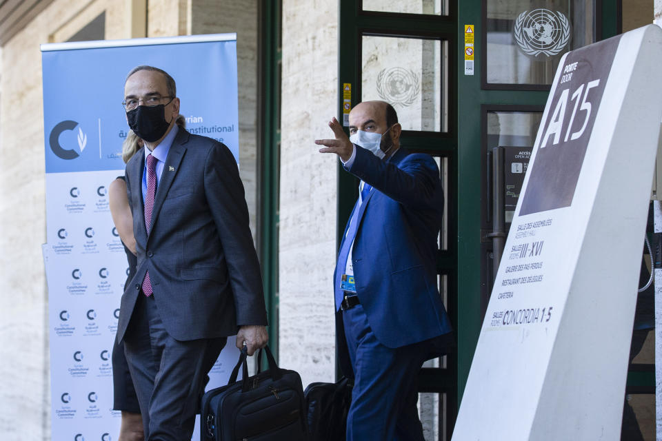 The Syrian Constitutional Committee Co-Chair Hadi al-Bahra, left, wearing face mask as precaution against the spread of the coronavirus as he leaves the building following the announcement of the suspension of the conference due to cases of Covid-19, affecting members of one of the delegations, at the European headquarters of the United Nations in Geneva, Switzerland, Monday, Aug. 24, 2020. (Salvatore Di Nolfi/Keystone via AP)