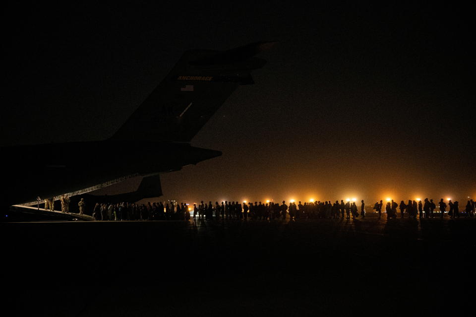 Evacuees from Afghanistan board a military aircraft during an evacuation from Kabul, in this photo taken on August 19, 2021 at undisclosed location and released on August 20, 2021.  (Staff Sgt. Brandon Cribelar/U.S. Marine Corps/Handout via Reuters)