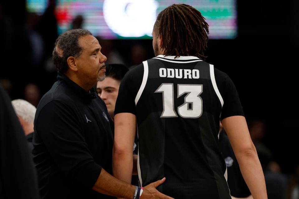 Georgetown head coach Ed Cooley, left, has a word with Providence forward Josh Oduro after their game at Capital One Arena.