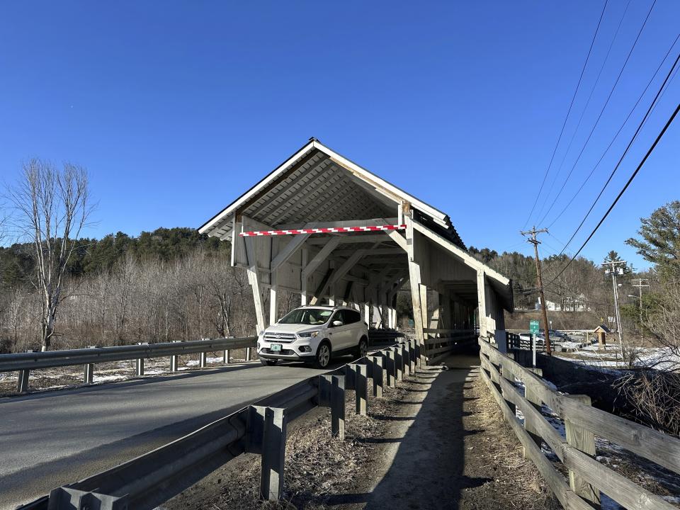 A vehicle passes through the Miller's Run covered bridge in Lyndon, Vt., on Tuesday, March 12, 2024. The historic bridge is under threat from truck drivers relying on GPS meant for cars continually hitting the bridge. (AP Photo/Lisa Rathke)