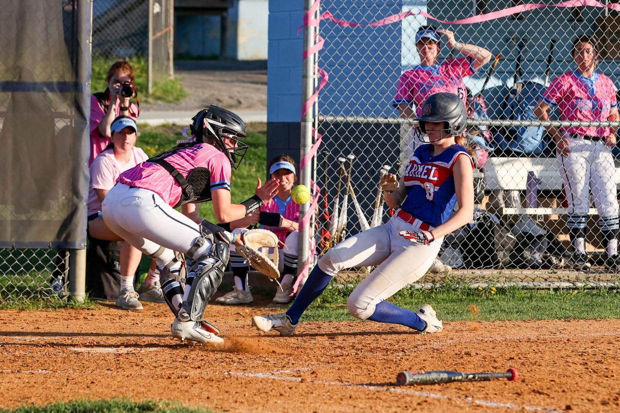 John Jay catcher Morgan Doughty awaits the ball to make a tag at home plate as Carmel's Lindsay Sikora slides in during John Jay's "Pink Out" softball game on May 1, 2024.