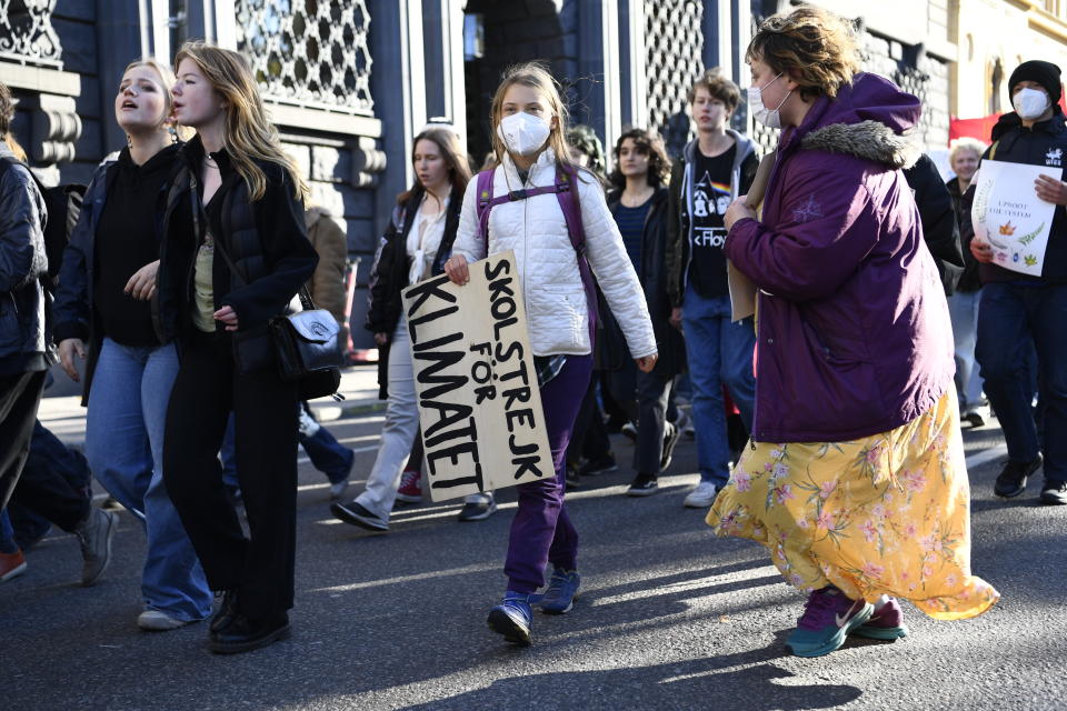 Greta Thunberg, in white jacket at center, takes part in "global climate strike" demonstration, organized by Fridays For Future in central Stockholm, Friday, Oct. 22, 2021. (Erik Simander/TT via AP)